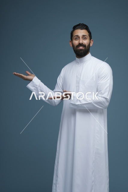 رجل سعودي بالثوب التقليدي يشير بتعبير مندهش