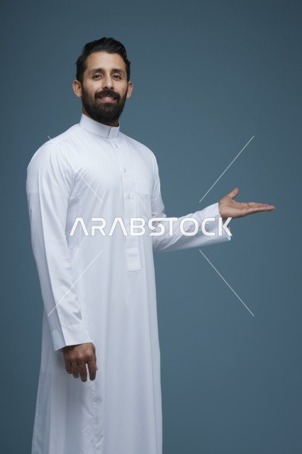 رجل سعودي بالثوب الأبيض يقدم إشارة في استوديو
