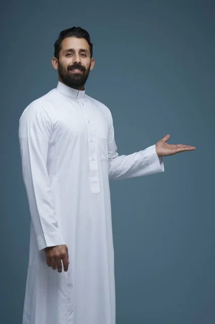 رجل سعودي بالثوب الأبيض يقدم إشارة في استوديو