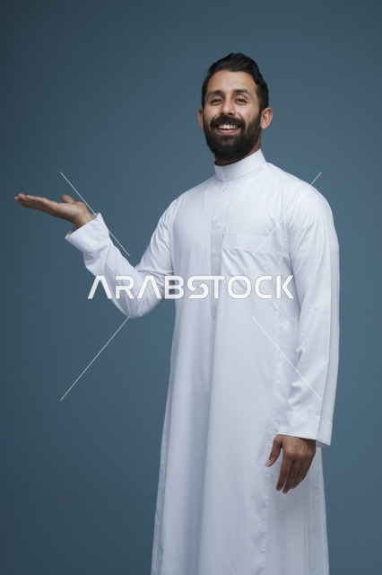 رجل سعودي بالثوب الأبيض يشير بيديه بحركة تقديمية