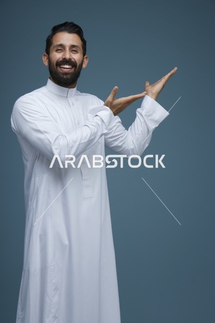 رجل سعودي بالثوب الأبيض يشير بيديه خلفية زرقاء