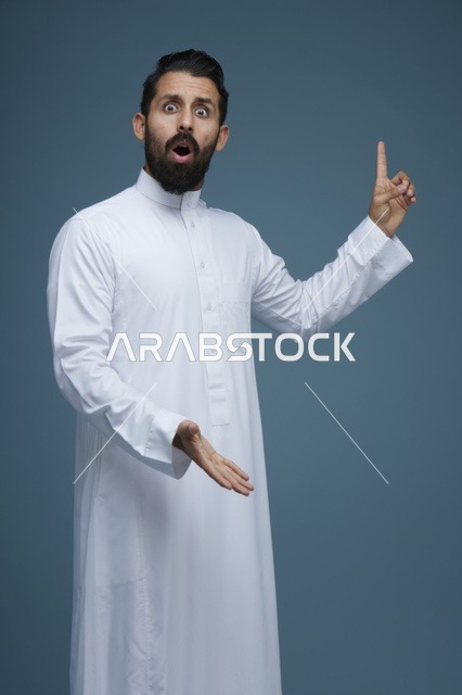 رجل سعودي بالثوب الأبيض يشير للأعلى بتعبير مندهش