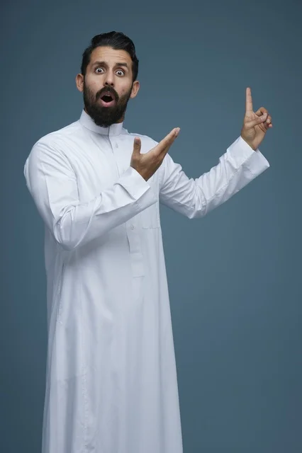 رجل سعودي مندهش يرتدي الثوب ويشير للأعلى