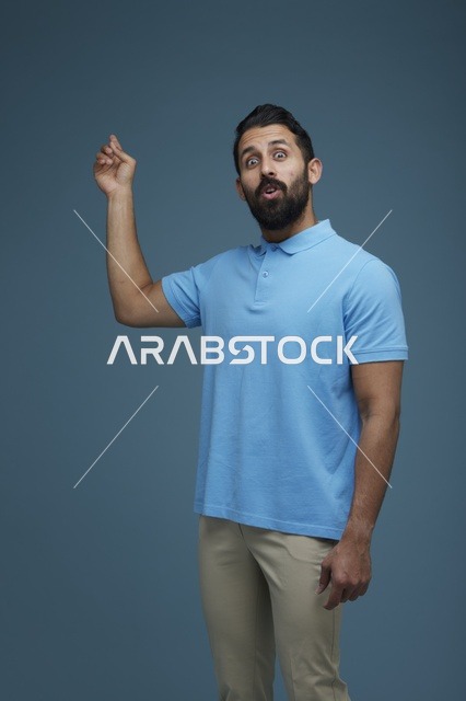 رجل سعودي مندهش يشير بيده بملابس كاجوال