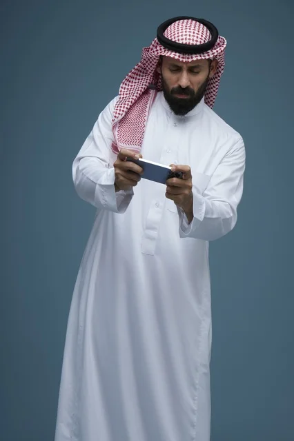 Saudi Man Playing Mobile Games on Smartphone in Studio