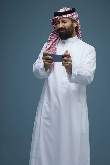 Saudi Man Playing Mobile Games on Smartphone in Studio