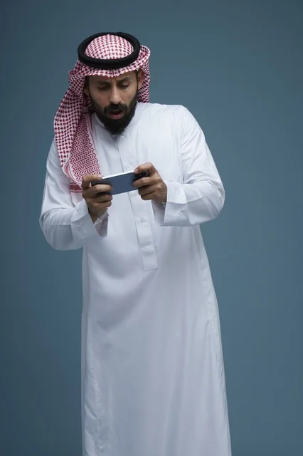 رجل سعودي يلعب بهاتفه الذكي في الاستوديو