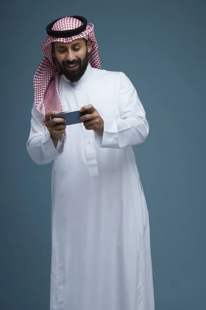 Saudi Man Playing Mobile Game on Smartphone