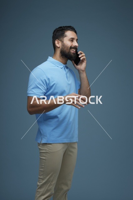 رجل سعودي يتحدث بالهاتف الذكي بملابس كاجوال