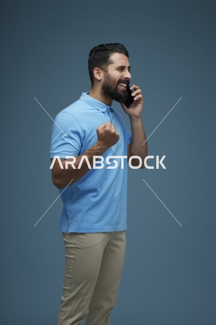 رجل سعودي يستخدم الهاتف الذكي ويحتفل بالنجاح