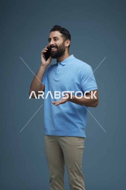 رجل سعودي يتحدث عبر الهاتف الذكي بملابس كاجوال