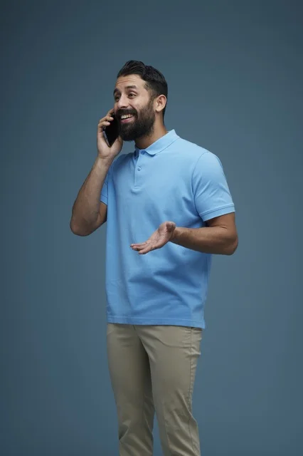 رجل سعودي بملابس كاجوال يتحدث عبر الهاتف الذكي في استوديو