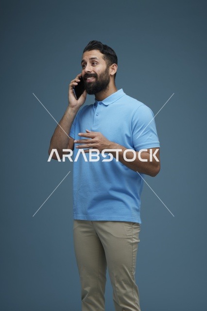 رجل سعودي يتحدث عبر الهاتف الذكي بإطلالة كاجوال