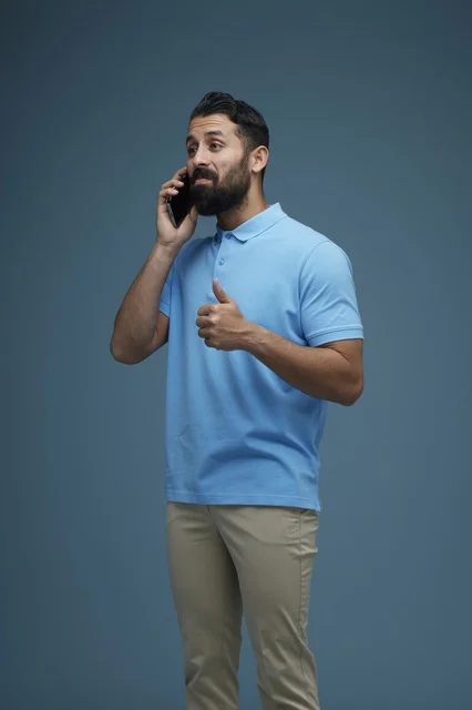 Saudi Man Talking on Smartphone Blue Studio Background