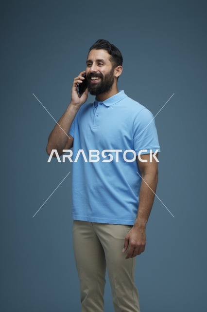 رجل سعودي يتحدث بالهاتف الذكي خلفية زرقاء