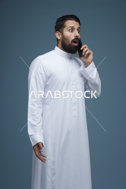رجل سعودي متفاجئ يتحدث بالهاتف في الاستوديو