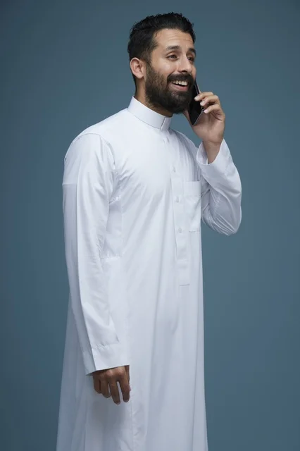 Saudi Man in Traditional Thobe Talking on Smartphone Studio