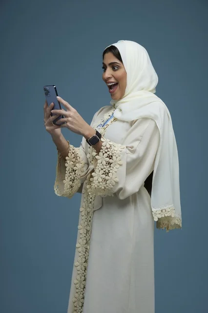 Saudi Woman with Smartphone and Surprised Expression