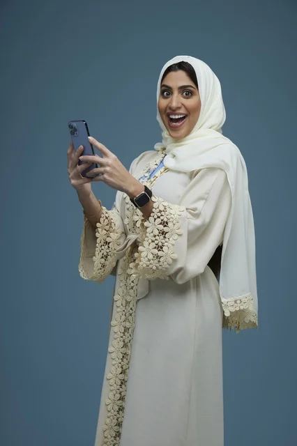 Saudi Woman Expressing Surprise with Smartphone in Cream Abaya Saudi Woman Expressing Surprise with Smartphone in Cream Abaya