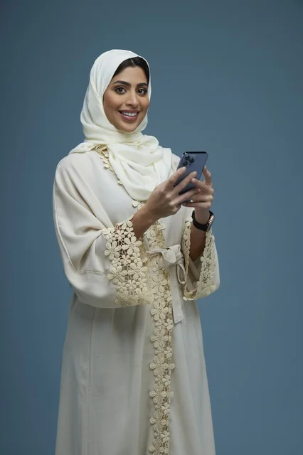 Saudi Woman in Cream Abaya Using Smartphone