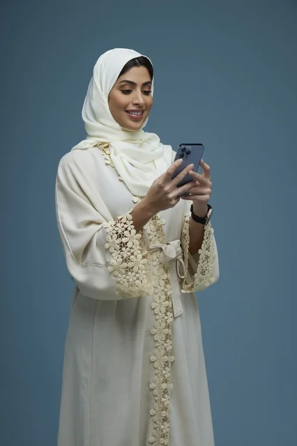 Saudi Woman Using Smartphone in Cream Abaya