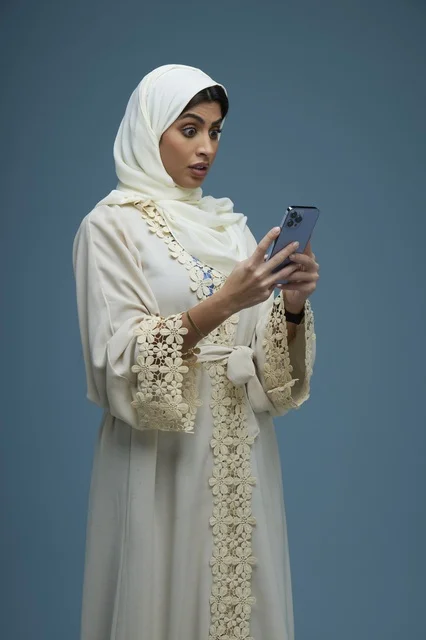 Saudi Woman with Smartphone and Shocked Expression