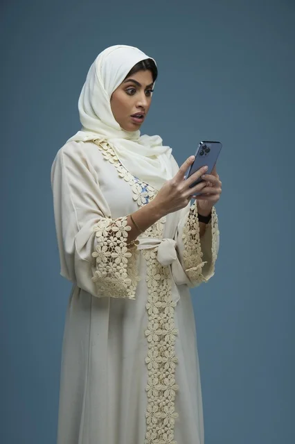Surprised Saudi Woman Looking at Smartphone in Abaya