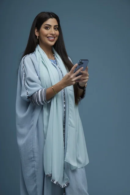 Saudi Woman Using Smartphone in Blue Abaya
