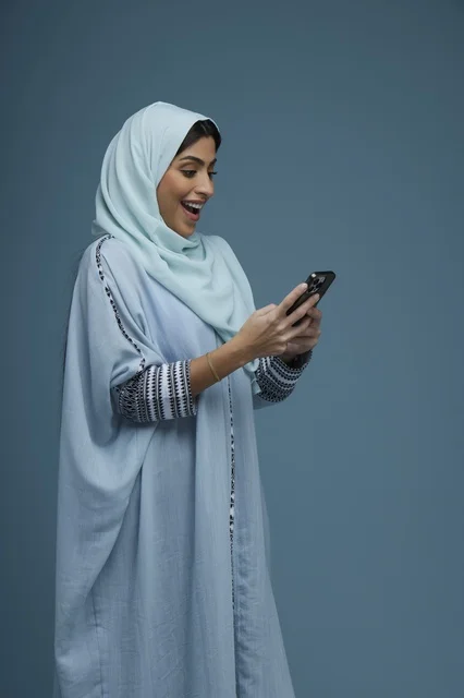 Excited Saudi Woman with Smartphone in Studio Shot