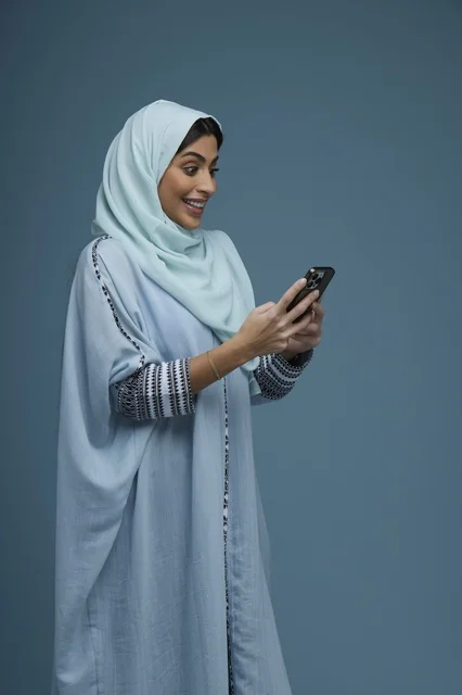 Excited Saudi Woman Using Smartphone in Abaya