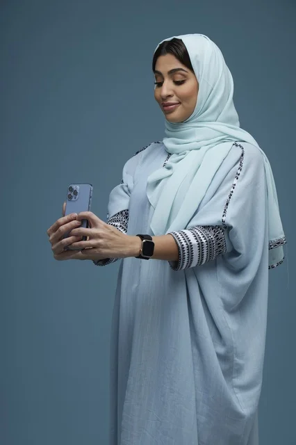 Saudi Woman Taking Selfie with Smartphone Blue Background