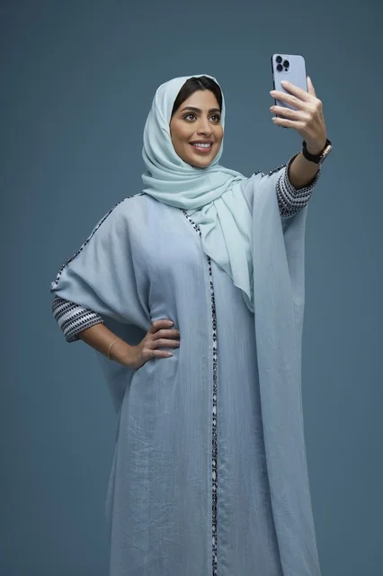 Saudi Woman Taking Smartphone Selfie in Blue Abaya