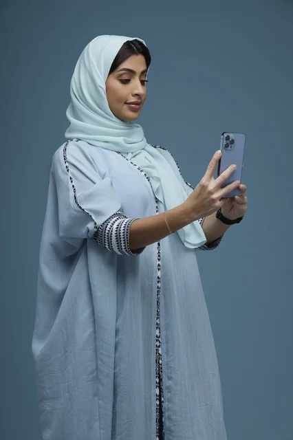 امرأة سعودية تلتقط سيلفي بالهاتف الذكي في استوديو