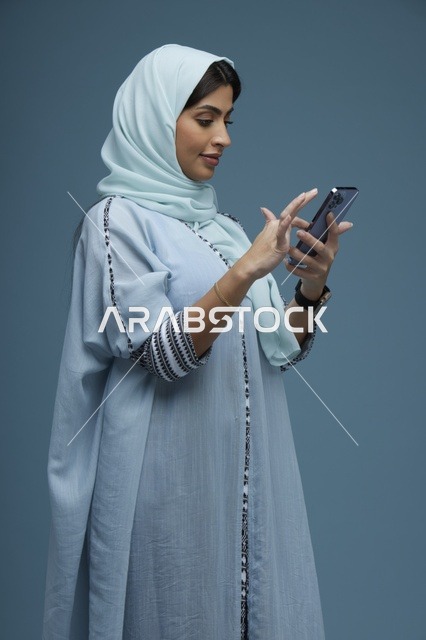امرأة سعودية تستخدم هاتفا ذكيا زاوية جانبية