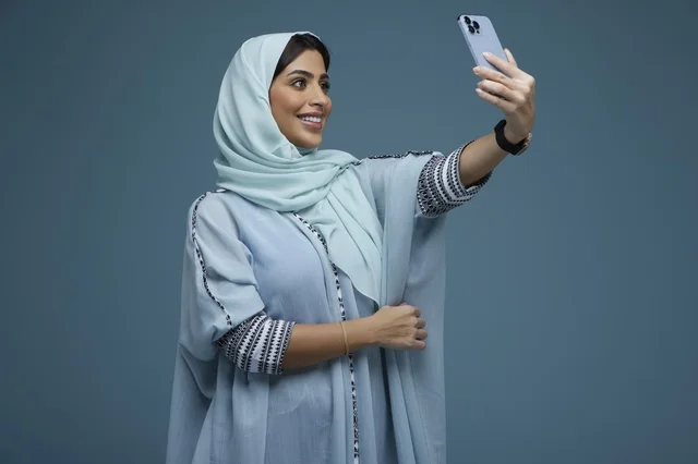 Saudi Woman Taking Selfie with Smartphone in Studio