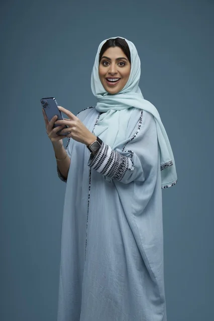 Saudi Woman with Smartphone on Blue Background