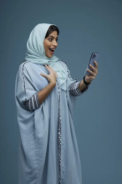 Surprised Saudi Woman Looking at Smartphone Screen