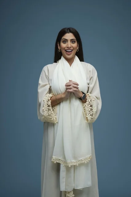 Excited Saudi Woman in White Abaya on Blue Background Excited Saudi Woman in White Abaya on Blue Background