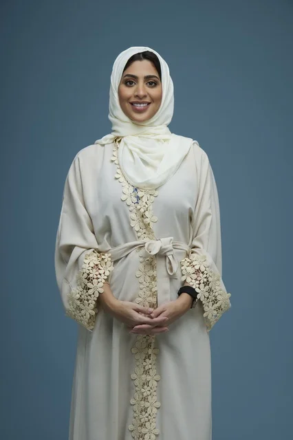 Saudi Woman in Beige Abaya on Blue Background