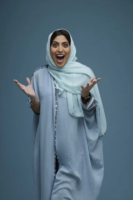Excited Saudi Woman in Abaya on Blue Background