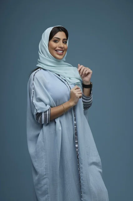 Saudi Woman in Blue Abaya Smiling in Studio Portrait