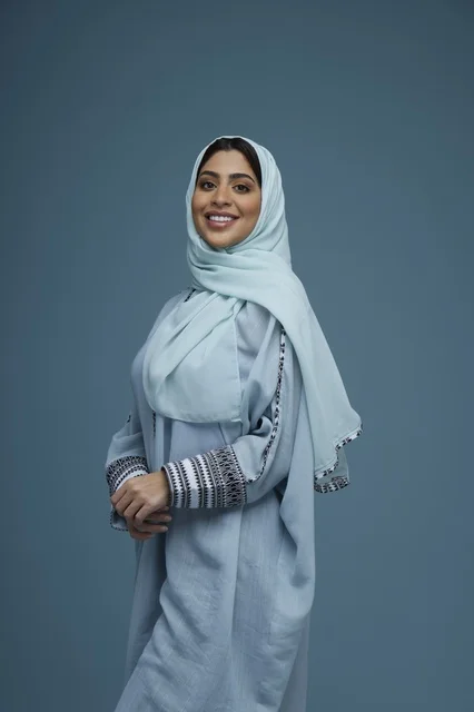 Smiling Saudi Woman in Blue Abaya Studio Portrait