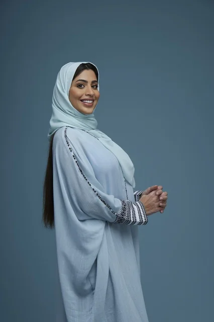 Smiling Saudi Woman in Blue Abaya Studio Portrait