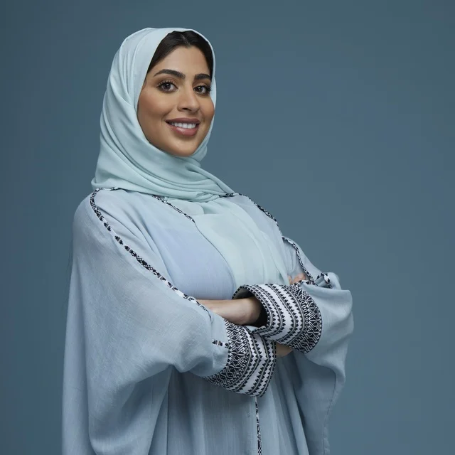 امرأة سعودية بعباءة زرقاء في استوديو تصوير