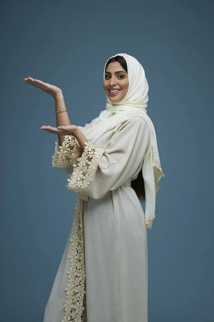 Saudi Woman in White Abaya Gesturing in Studio