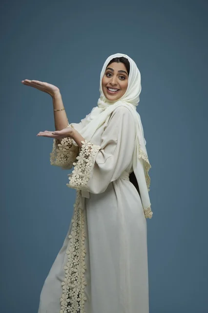 Saudi Woman in White Abaya Presenting on Blue Background