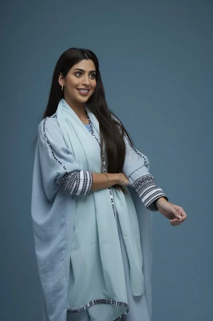 Smiling Saudi Woman in Blue Embroidered Abaya Studio