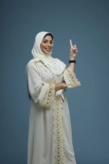 امرأة سعودية تشير للأعلى في استوديو تصوير