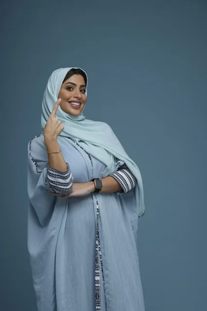 Saudi Woman in Blue Abaya Pointing Upwards
