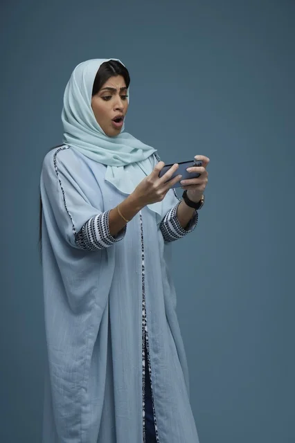 Surprised Saudi Woman Using Smartphone in Studio